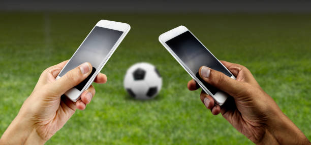 Friends using mobile phone and betting during a football or soccer match